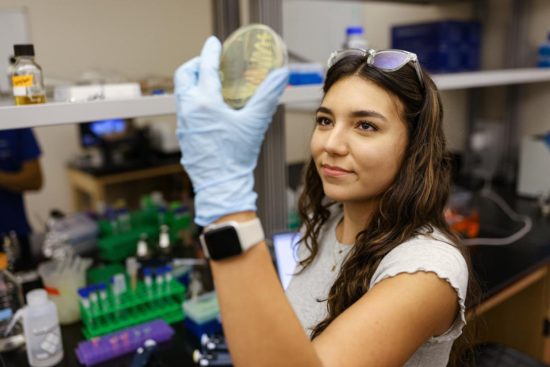 Lizbett Ocana 23 Examines Sample In Biology Lab